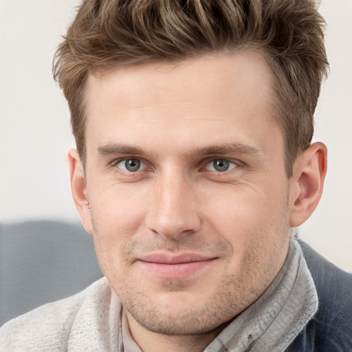 Joyful white young-adult male with short  brown hair and grey eyes