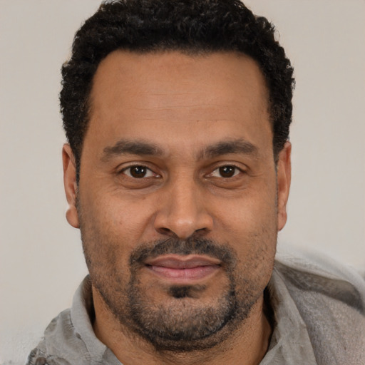 Joyful latino adult male with short  black hair and brown eyes