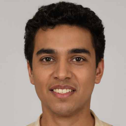 Joyful latino young-adult male with short  black hair and brown eyes