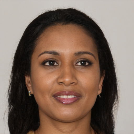 Joyful black young-adult female with long  brown hair and brown eyes