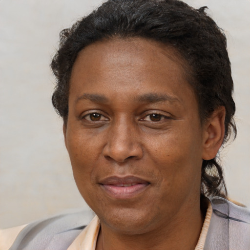 Joyful black adult female with short  brown hair and brown eyes