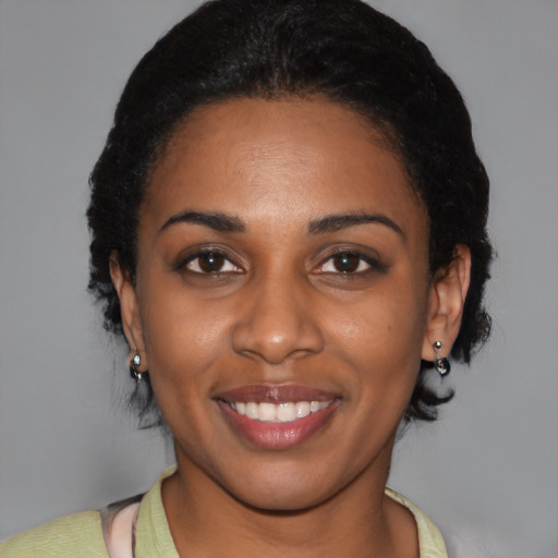 Joyful black young-adult female with short  black hair and brown eyes