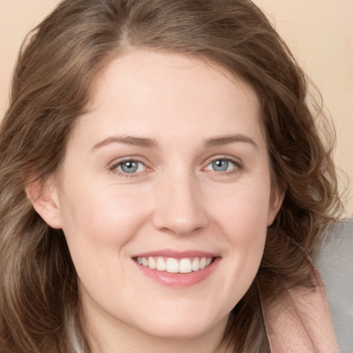 Joyful white young-adult female with long  brown hair and green eyes