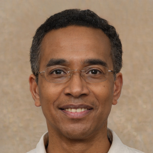 Joyful black adult male with short  black hair and brown eyes