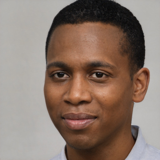 Joyful black young-adult male with short  brown hair and brown eyes