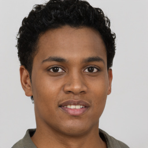 Joyful black young-adult male with short  black hair and brown eyes