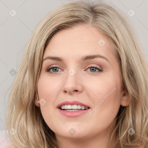 Joyful white young-adult female with long  brown hair and blue eyes