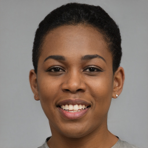 Joyful black young-adult female with short  black hair and brown eyes