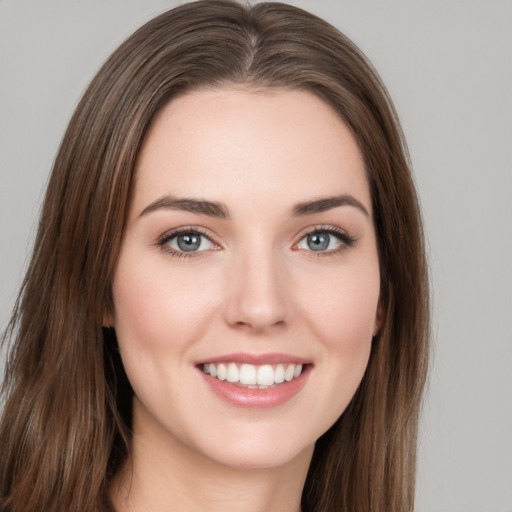 Joyful white young-adult female with long  brown hair and grey eyes