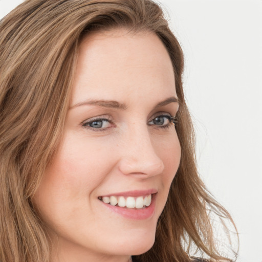 Joyful white young-adult female with long  brown hair and blue eyes