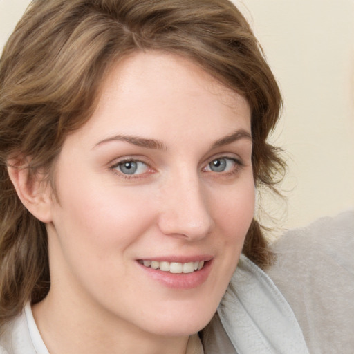 Joyful white young-adult female with medium  brown hair and blue eyes