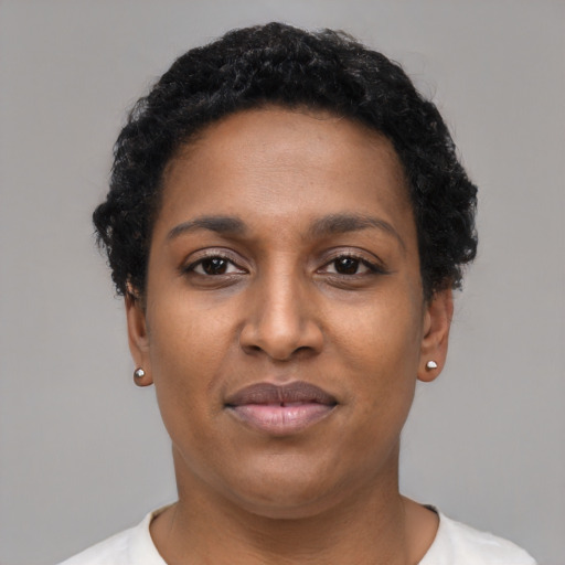 Joyful black young-adult female with short  black hair and brown eyes