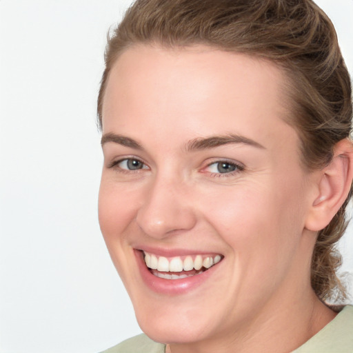 Joyful white young-adult female with medium  brown hair and green eyes