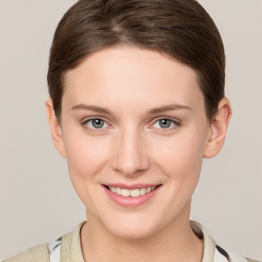 Joyful white young-adult female with short  brown hair and grey eyes