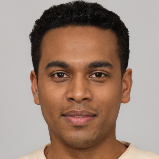 Joyful black young-adult male with short  black hair and brown eyes