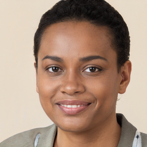 Joyful black young-adult female with short  black hair and brown eyes