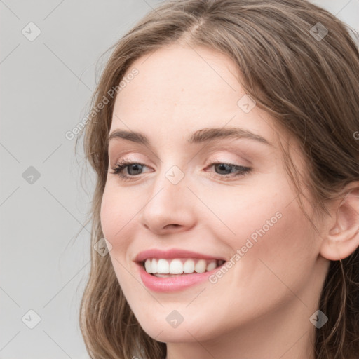 Joyful white young-adult female with long  brown hair and blue eyes