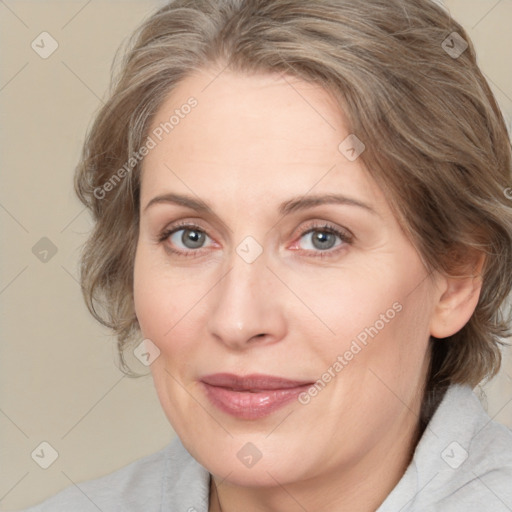 Joyful white adult female with medium  brown hair and blue eyes