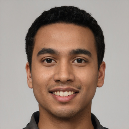 Joyful latino young-adult male with short  black hair and brown eyes