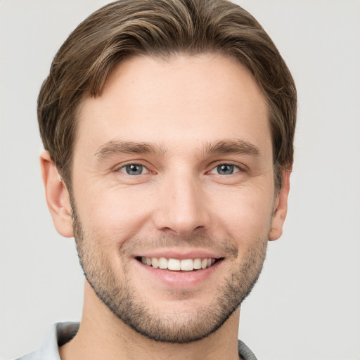 Joyful white young-adult male with short  brown hair and grey eyes