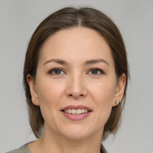 Joyful white adult female with medium  brown hair and brown eyes