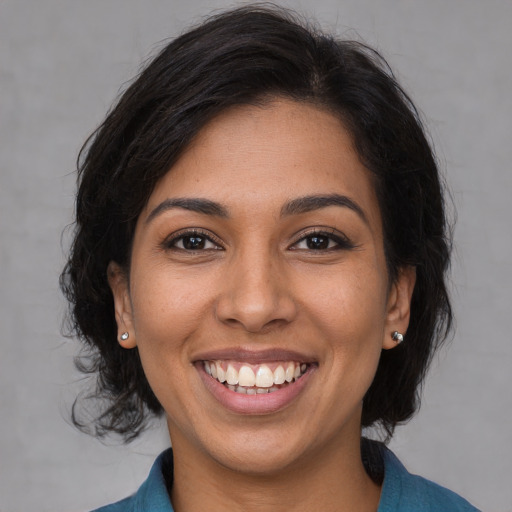 Joyful latino young-adult female with medium  brown hair and brown eyes