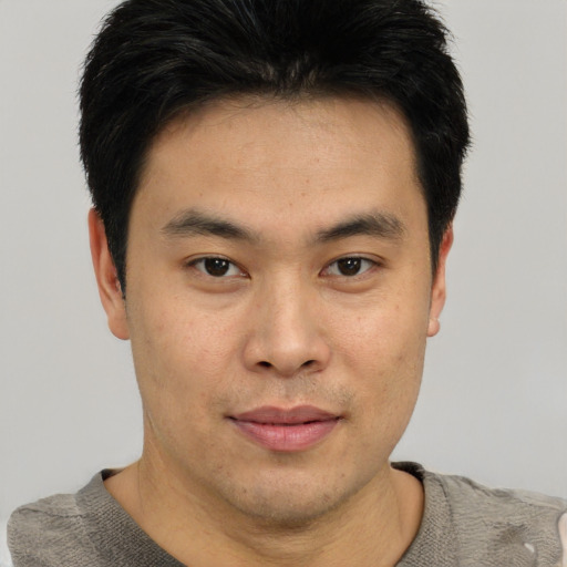 Joyful asian young-adult male with short  black hair and brown eyes