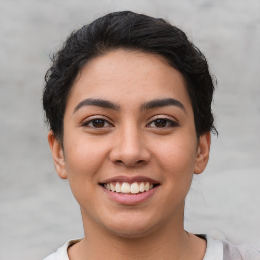 Joyful latino young-adult female with short  black hair and brown eyes