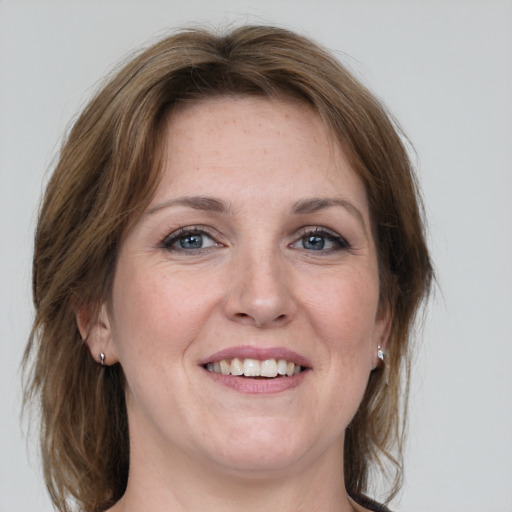 Joyful white young-adult female with medium  brown hair and grey eyes