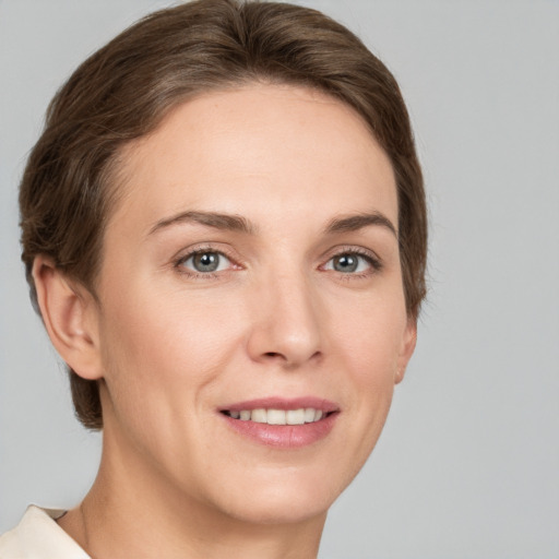 Joyful white young-adult female with short  brown hair and grey eyes