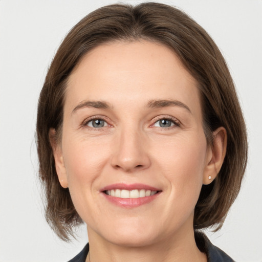 Joyful white adult female with medium  brown hair and grey eyes