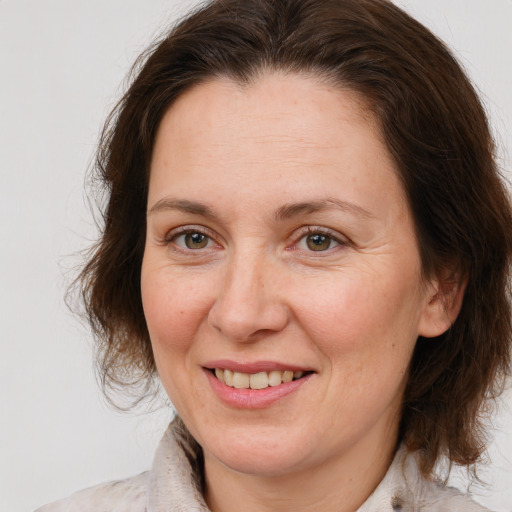 Joyful white adult female with medium  brown hair and brown eyes