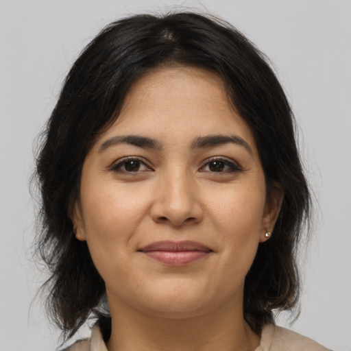 Joyful latino young-adult female with medium  brown hair and brown eyes