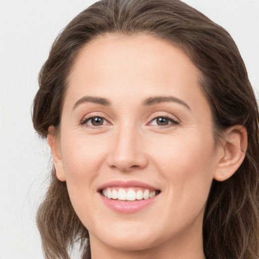 Joyful white young-adult female with long  brown hair and brown eyes