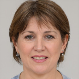 Joyful white adult female with medium  brown hair and grey eyes