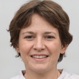 Joyful white adult female with medium  brown hair and grey eyes