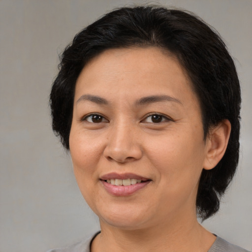 Joyful asian adult female with medium  brown hair and brown eyes
