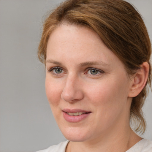 Joyful white young-adult female with medium  brown hair and blue eyes