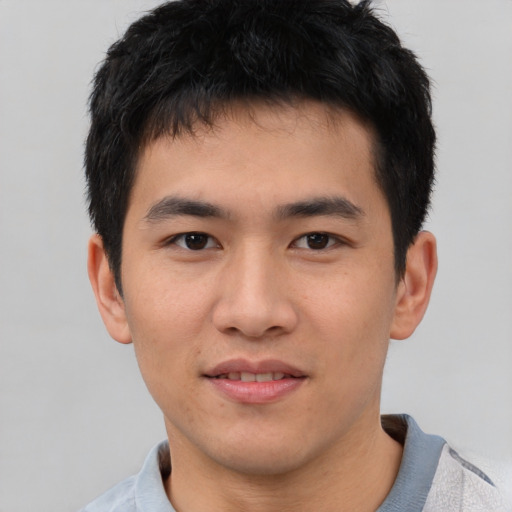 Joyful asian young-adult male with short  black hair and brown eyes