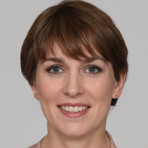 Joyful white young-adult female with medium  brown hair and grey eyes