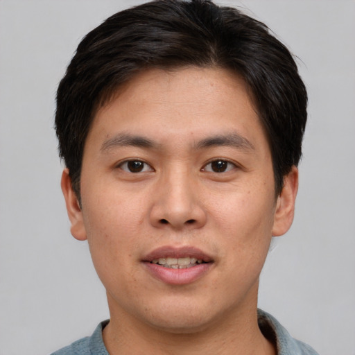 Joyful asian young-adult male with short  brown hair and brown eyes