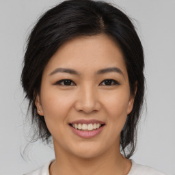 Joyful asian young-adult female with medium  brown hair and brown eyes