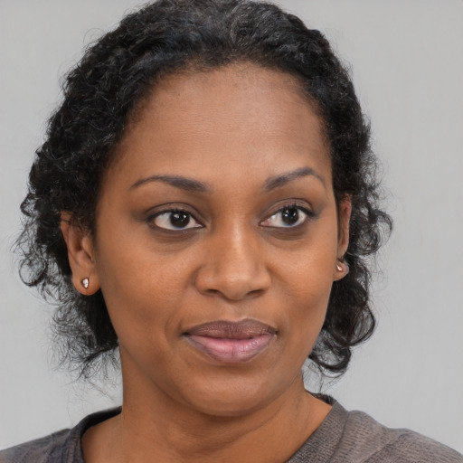 Joyful black adult female with medium  brown hair and brown eyes