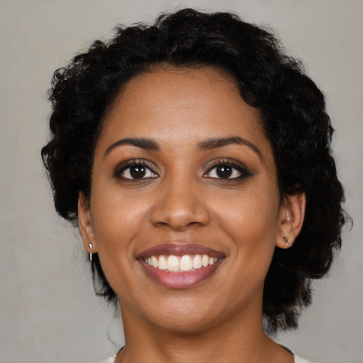 Joyful black young-adult female with medium  brown hair and brown eyes