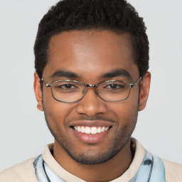 Joyful black young-adult male with short  brown hair and brown eyes