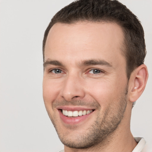 Joyful white young-adult male with short  brown hair and brown eyes