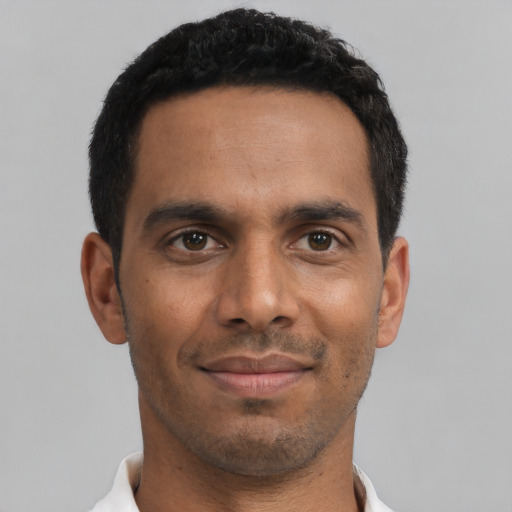 Joyful latino young-adult male with short  black hair and brown eyes