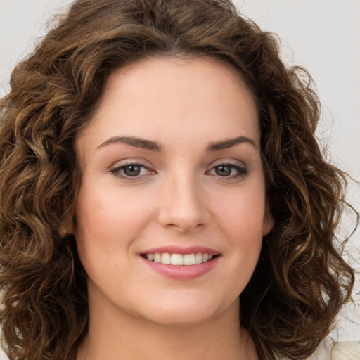 Joyful white young-adult female with long  brown hair and green eyes