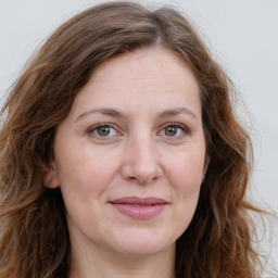 Joyful white young-adult female with long  brown hair and green eyes