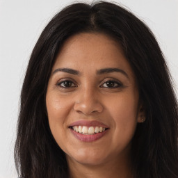 Joyful latino young-adult female with long  brown hair and brown eyes